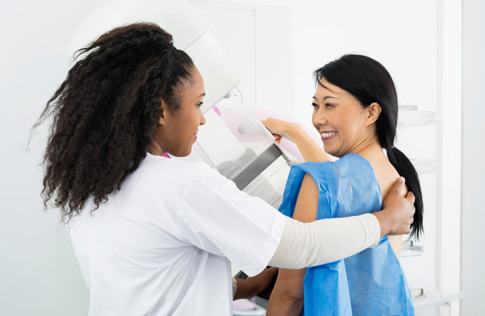Technician assisting patient during mammogram exam